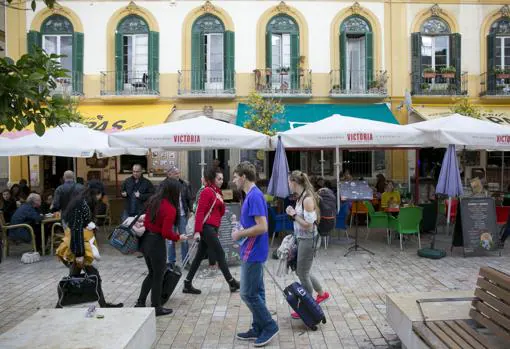 Unos turistas caminan por la céntrica plaza de la Merced de Málaga