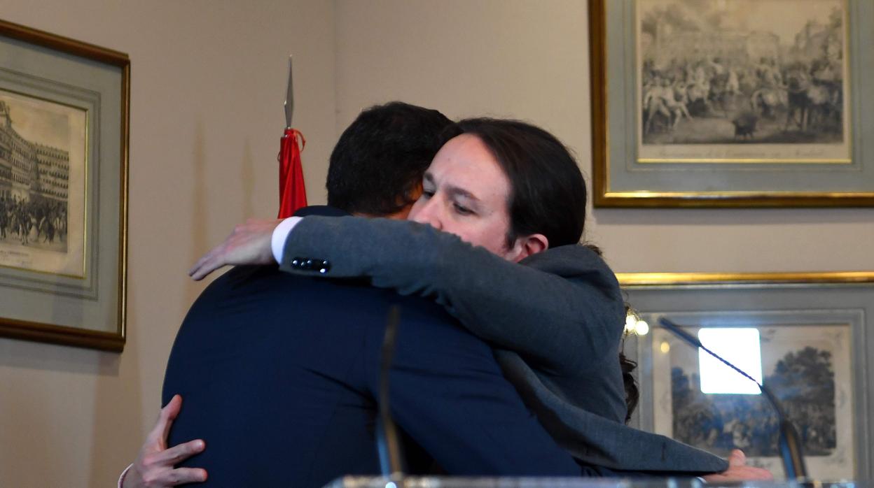 Pablo Iglesias abraza a Pedro Sánchez tras el anuncio del acuerdo para formar Gobierno entre PSOE y Podemos