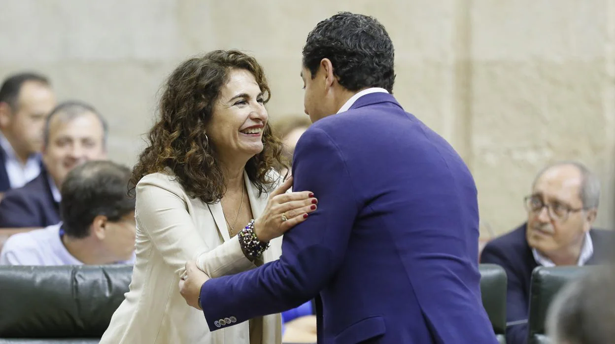 Foto de archivo en la que aparece la ahora ministra de Hacienda, María Jesús Montero (izda) saluda al hoy presidente de Andalucía Juanma Moreno
