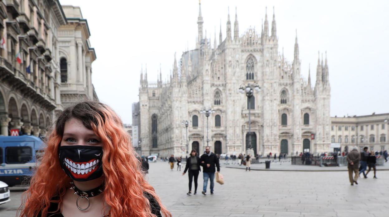 Una mujer con una máscara en la plaza del Duomo en Milán