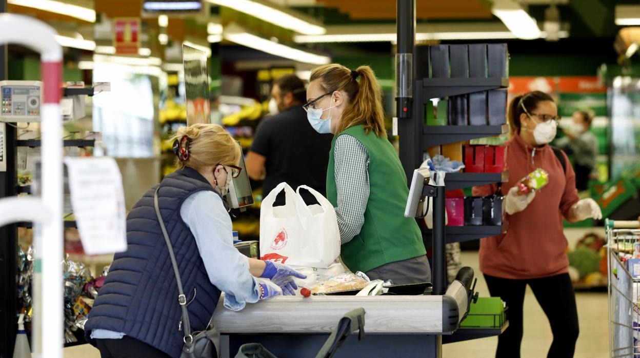 Una cajera con mascarilla en un supermercado de Córdoba