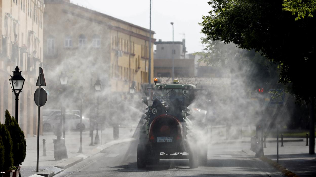 Un tractor colabora en la desinfección en Córdoba de las calles en la pandemia del coronavirus