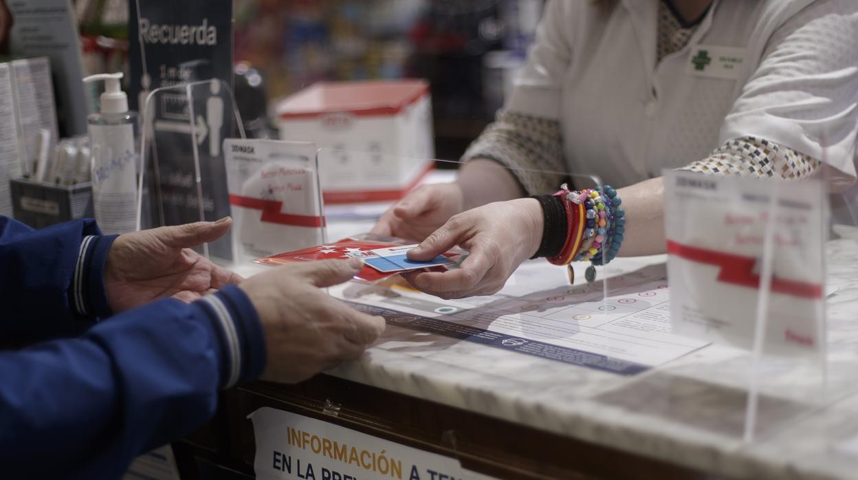 Un cliente compra una mascarilla en una farmacia