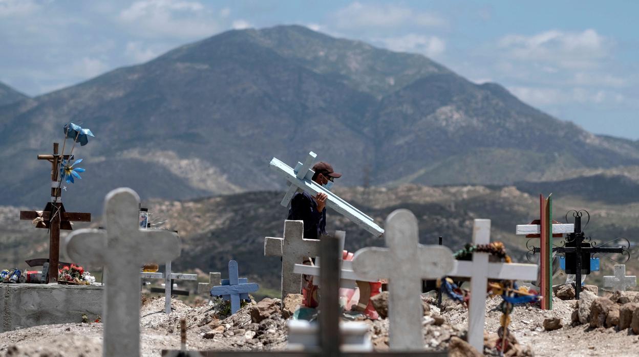 Un trabajador carga con una cruz en el cementerio muncipal de Tijuana. El país supera ya las 4.000 víctimas mortales por Covid-19