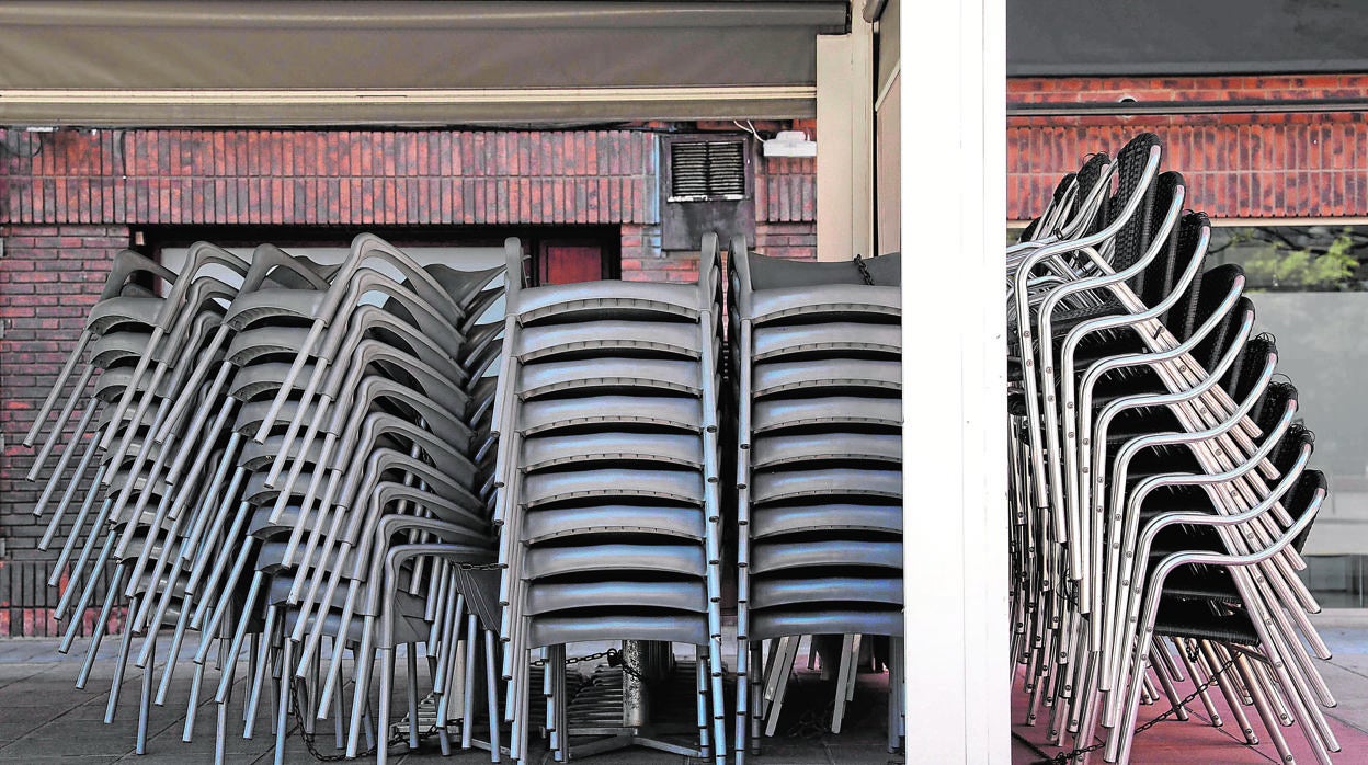 Sillas y mesas recogidas en una terraza de un bar de Valencia