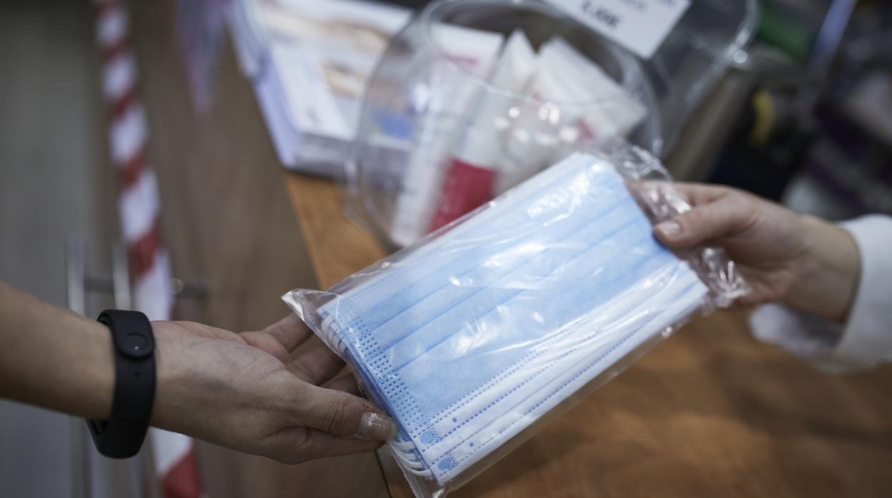 Una clienta comprando mascarillas en una farmacia de Madrid