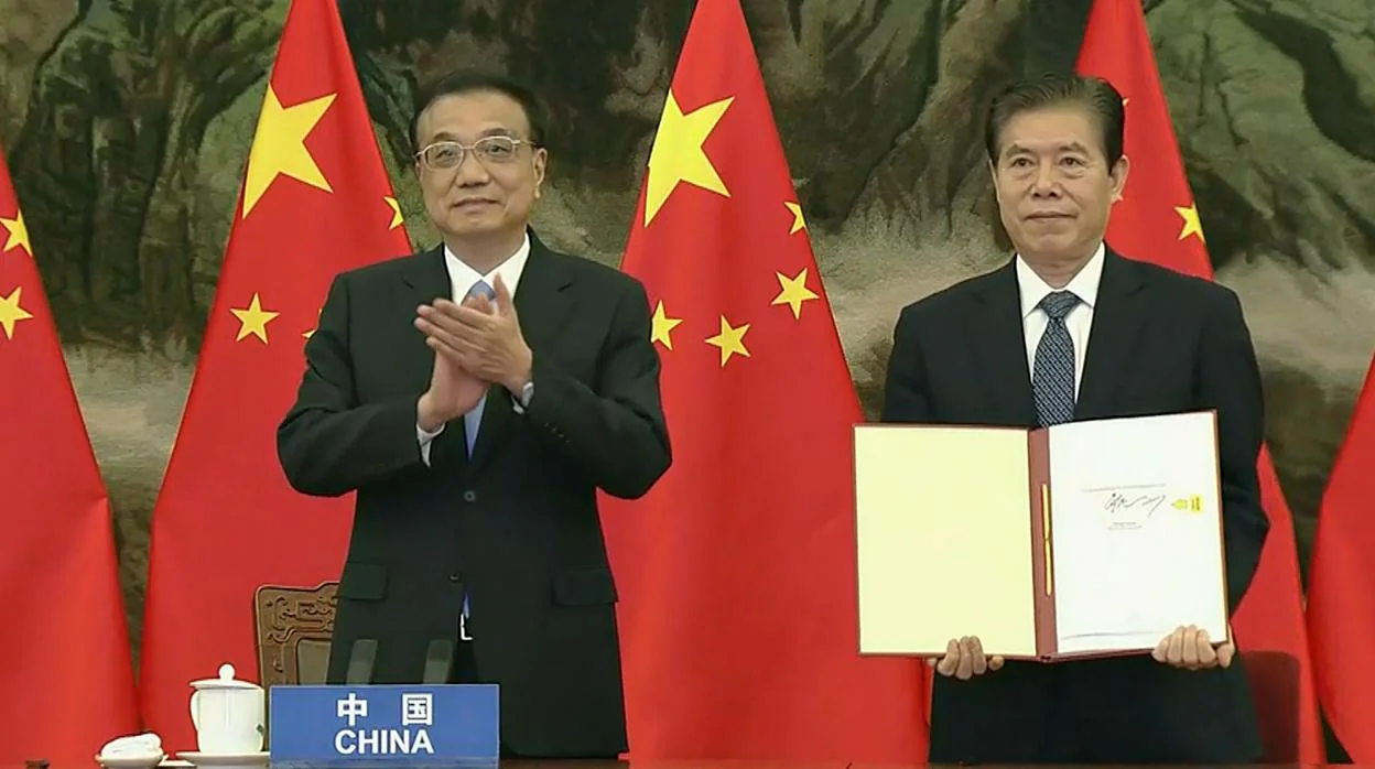 El «premier» chino, Li Keqiang, y el ministro de comercio, Zhong Shan, sosteniendo el acuerdo durante la ceremonia de la firma de la Asociación Integral Regional (RCEP)