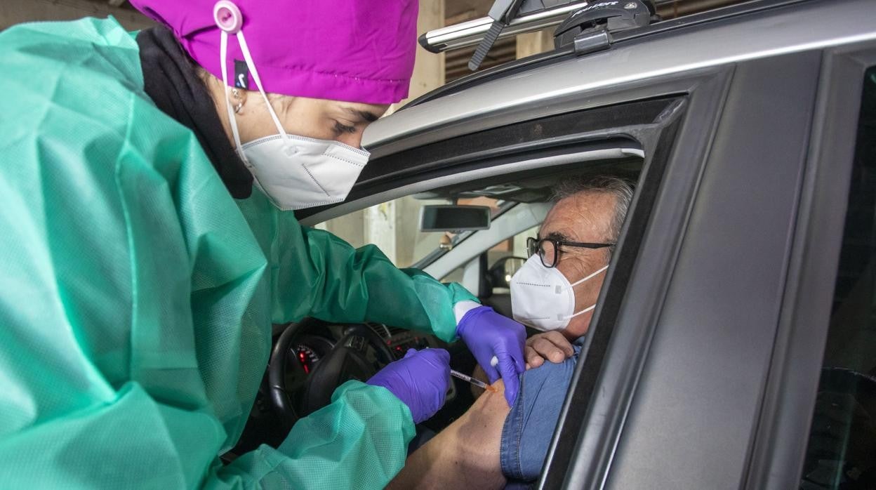 Una enfermera pone la vacuna del Covid-19 a un ciudadano en su propio coche en el dispositivo del estadio Colombino de Huelva montado por Salud