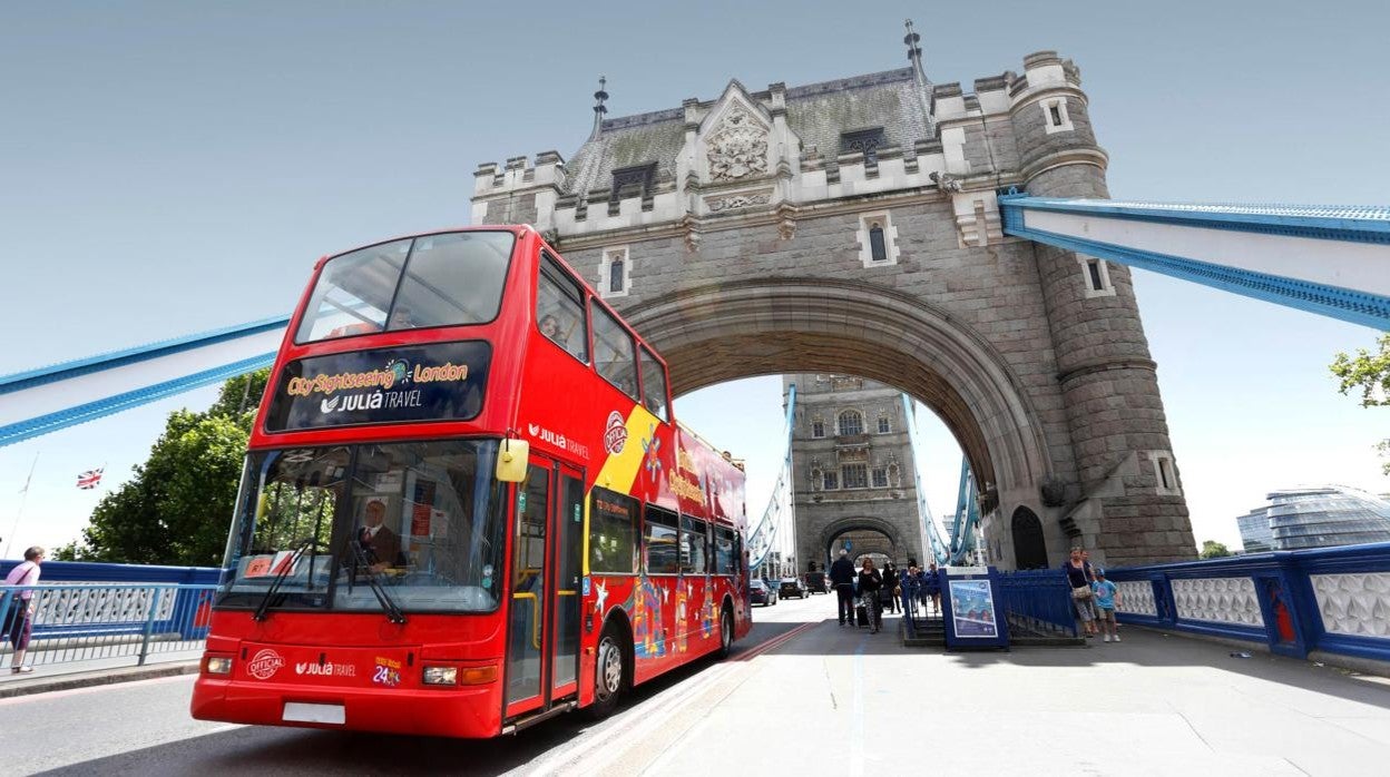 Uno de los autobuses rojos panorámicos de dos plantas de la marca sevillana circula por el icónico puente de la Torre de Londres (Tower Brigde)