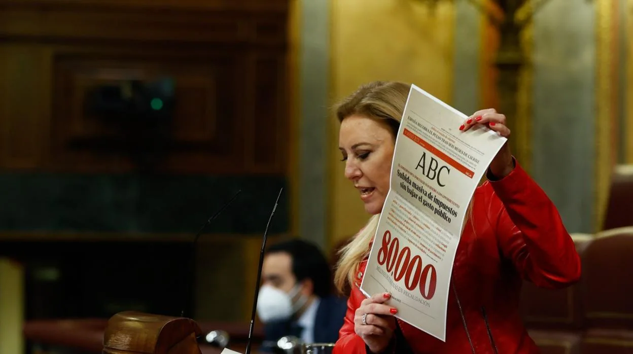 La diputada popular Carolina España muestra una portada de ABC durante su intervención en el Pleno