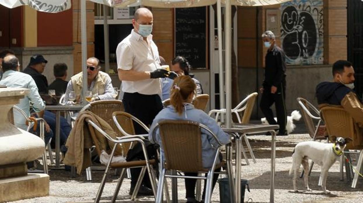 Un camarero atiende mesas en el centro de Sevilla