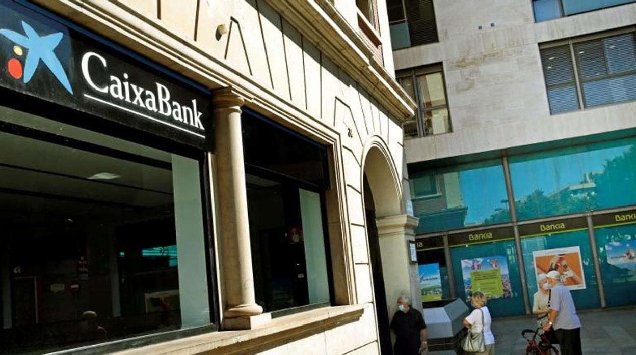 Varios clientes se disponen a entrar a una oficina de CaixaBank