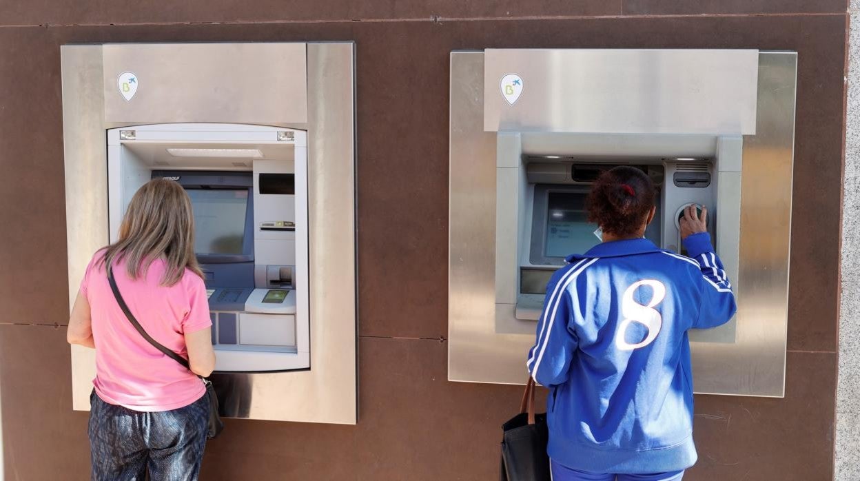 Dos mujeres operando a través del cajero automático