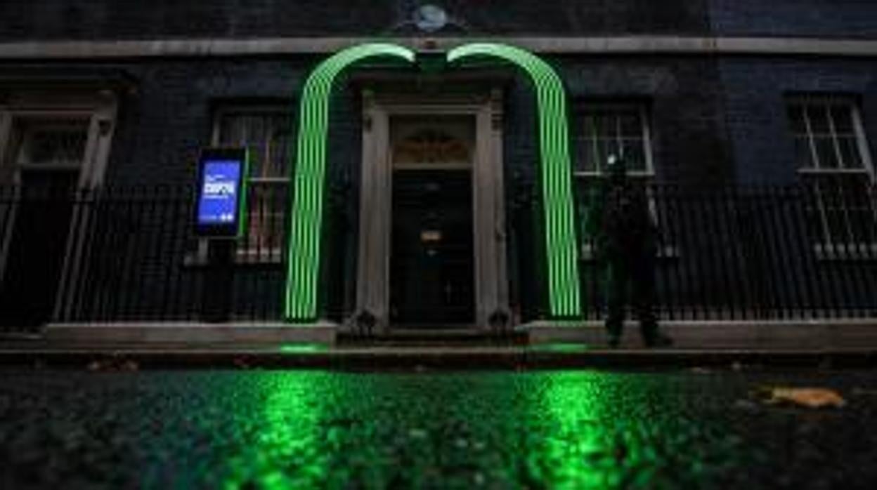 Un arco verde se ilumina sobre la puerta del número 10 de Downing Street, en Londres, un símbolo de la preparación para la cumbre COP26 que tendrá lugar en Glasgow