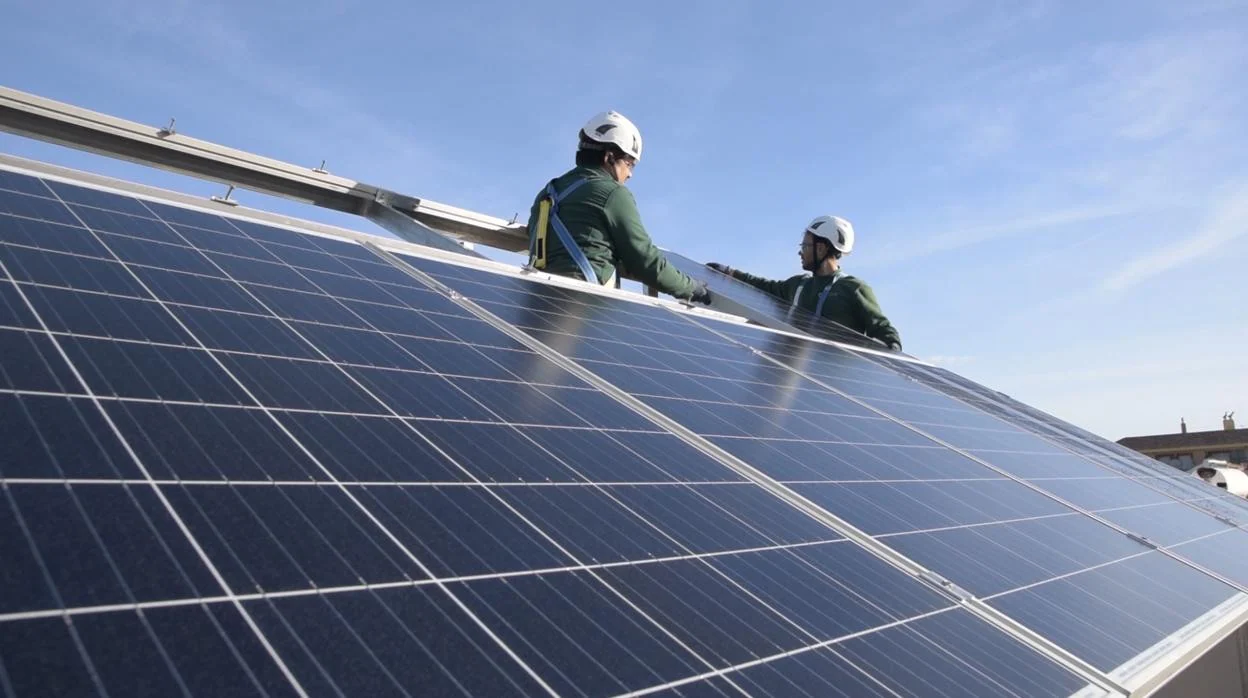 Dos operarios instalan placas solares