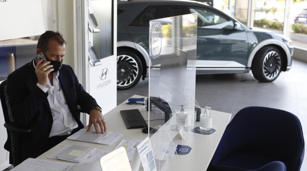 Un trabajador atiende el teléfono en un concesionario de coches de Córdoba