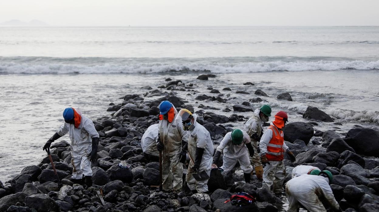 Trabajadores peruanos limpian el petróleo de las playas tras el desastre ecológico