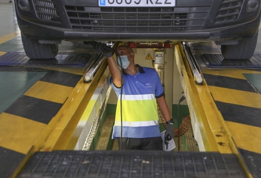 Un mecánico inspecciona los bajos de un vehículo en una estación de ITV sevillana