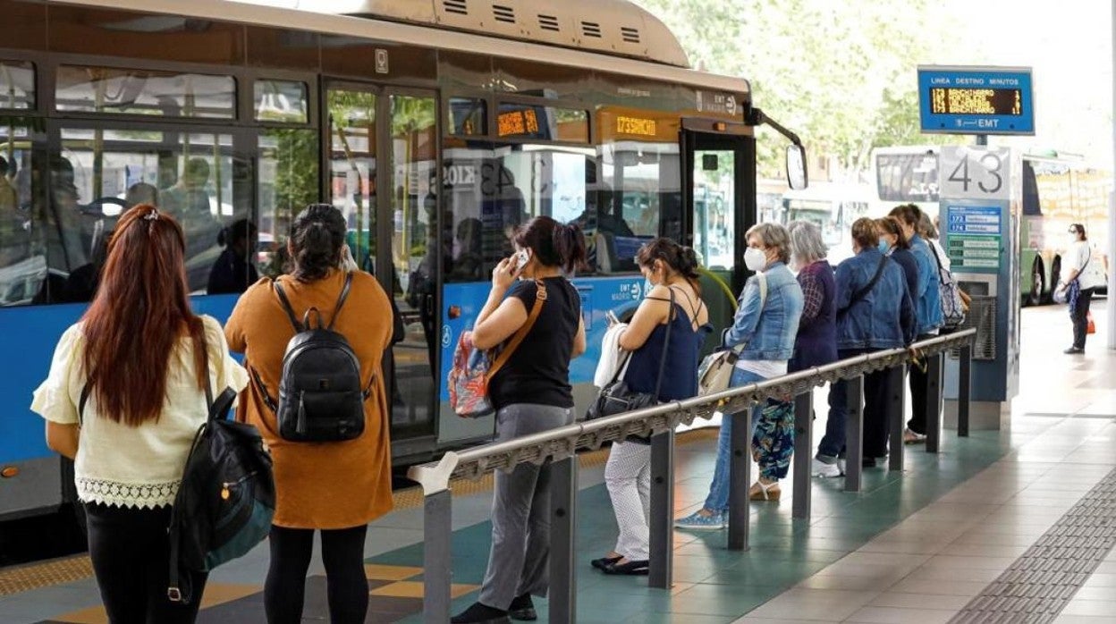 Un grupo de usuarios de transporte público esperan en una parada