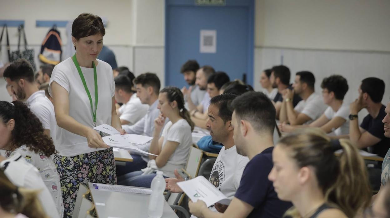 Una profesora entrega los exámenes a opositores en la Escuela de Ingenieros de Sevilla