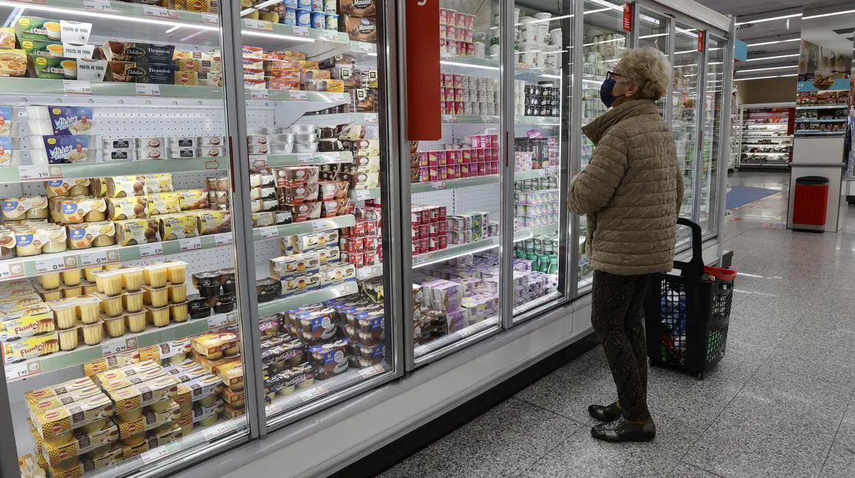 Una mujer comprueba los precios de los productos de un supermercado