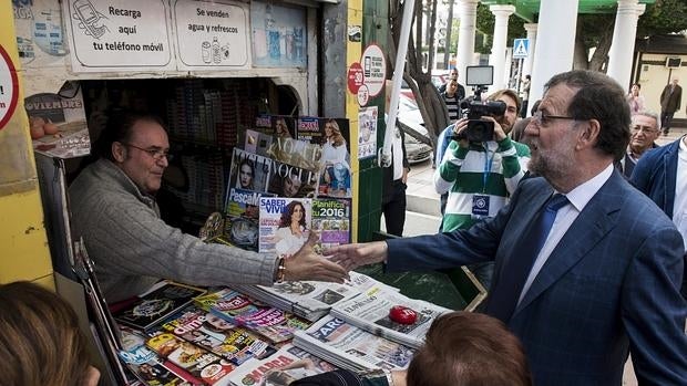 Rajoy saluda a un quiosquero durante su visita en víspera del inicio de campaña electoral a Melilla