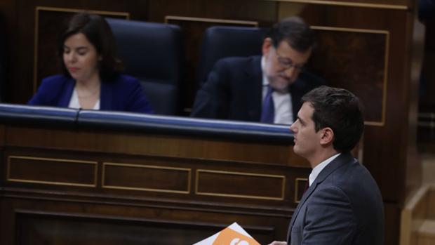 Rivera pasa junto a los escaños de Soraya Saénz de Santamería y Mariano Rajoy