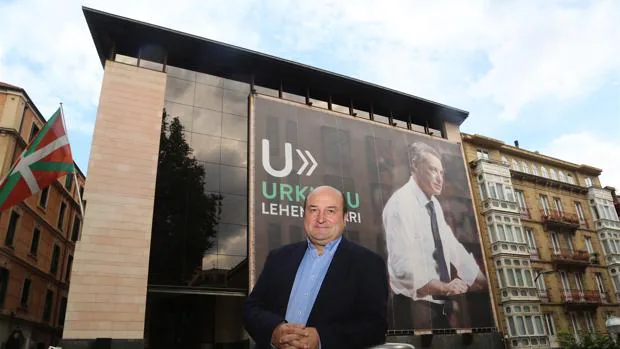 Andoni Ortuzar, ante la sede de Sabin Etxea, con el cartel de Urkullu de fondo