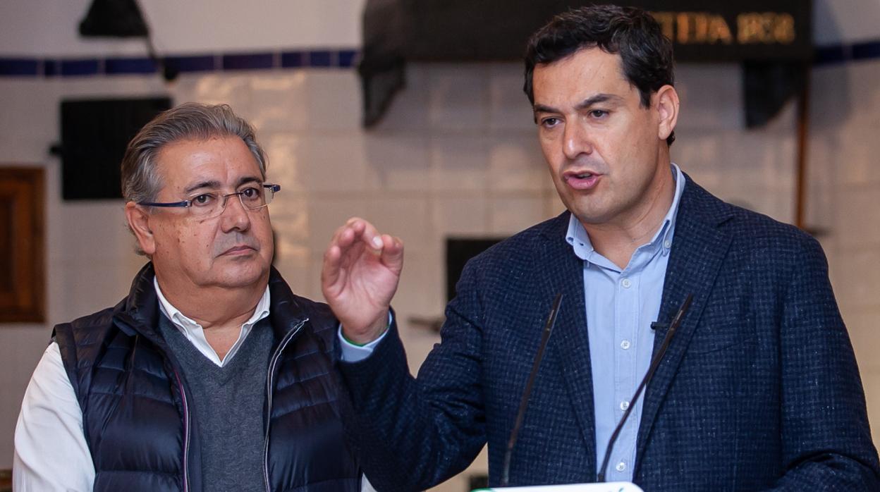 El candidato número uno del PP por Sevilla en las elecciones en Andalucía, Juan Ignacio Zoido, junto al candidato del PP a la Junta de Andalucía, Juanma Moreno, durante su visita este miércoles a una fábrica de polvorones en Estepa