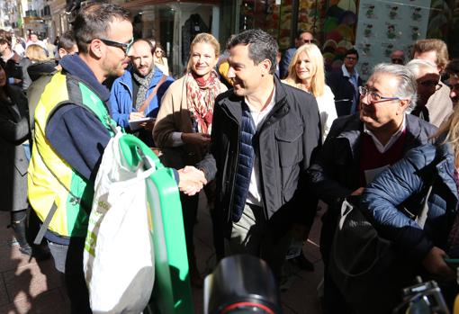 El candidato popular saluda a un vendedor de la ONCE este lunes en Sevilla