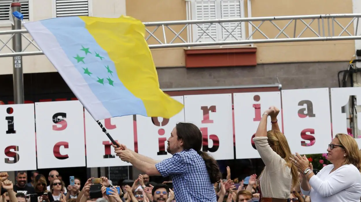 Pablo Iglesias con la bandera canaria de las siete estrellas verdes