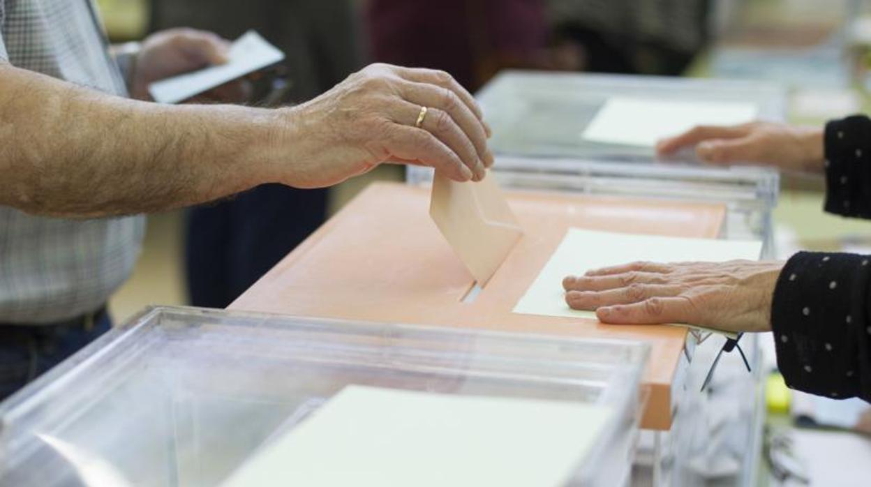 Un hombre deposita su voto en una mesa electoral