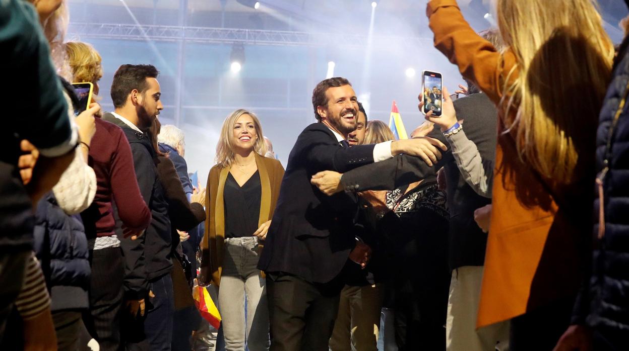 Pablo Casado saluda a simpatizantes del PP, seguido de su mujer