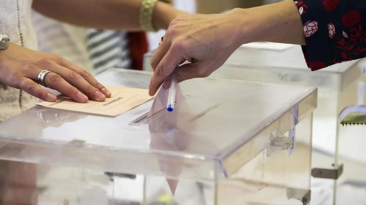 Una mujer deposita su voto en una urna de un colegio electotal