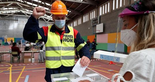 Un empleado de Alcoa votando con ropa de trabajo para reivindicar futuro para la factoría