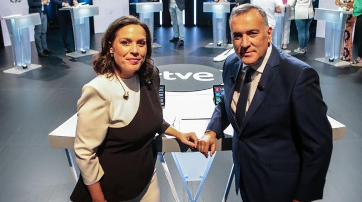Paloma Jara y Xabier Fortes delante de los candidatos en el plató del debate de televisión