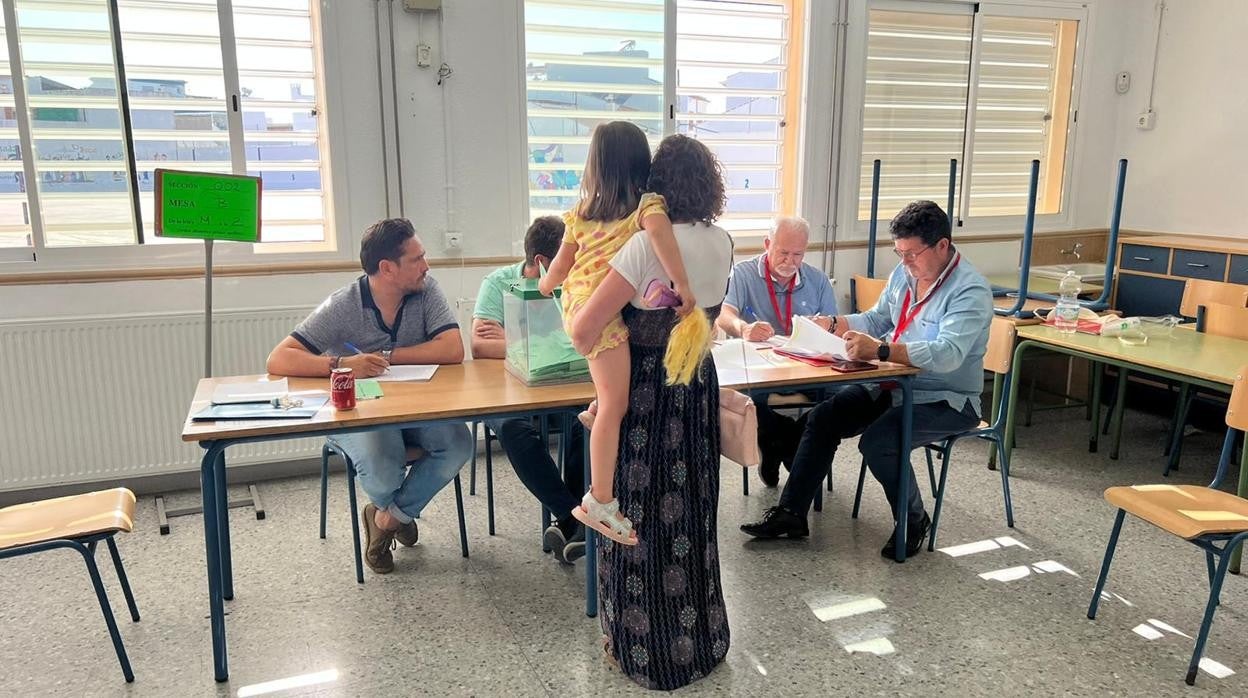 Una mujer vota acompañada de una niña en Almonte