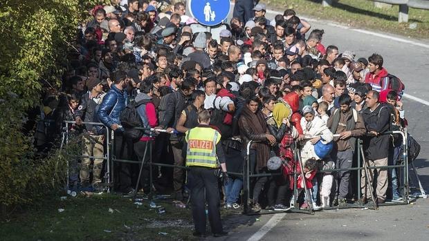 Un grupo de refugiados espera en la frontera entre Alemania y Austria