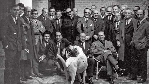 Asistentes a la reunión de la Comisión Española del Congreso por la Libertad de la Cultura celebrada en la casa toledana del arquitecto Chueca Goitia, quien aparece sentado, en el centro, acariciando a su perro