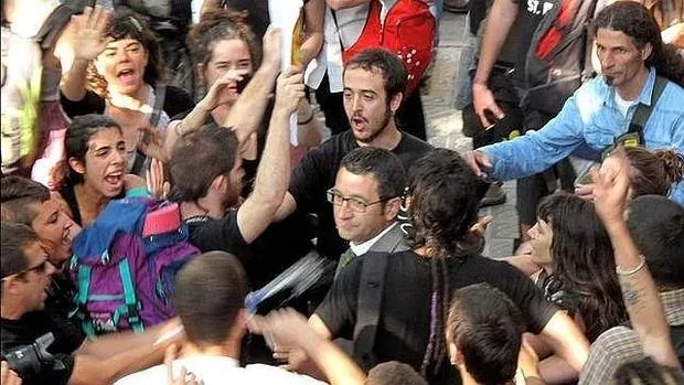 El diputado del PSC Jordi Terrades (en el centro, con gafas), increpado en las inmediaciones del Parlamento catalán