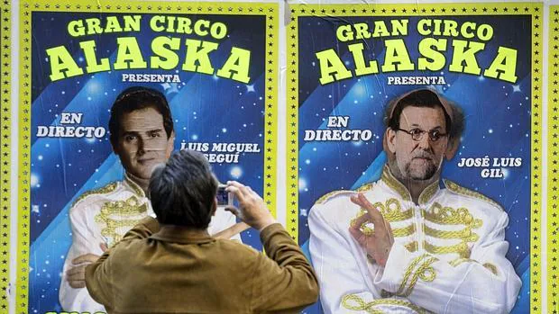 Un vecino observa el cartel modificado en el que aparecen juntos Rivera y Rajoy