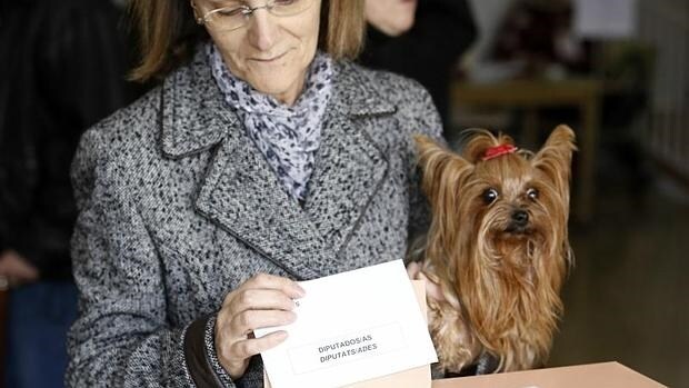 Una ciudadana ejerce su derecho al voto en Valencia, mascota en ristre