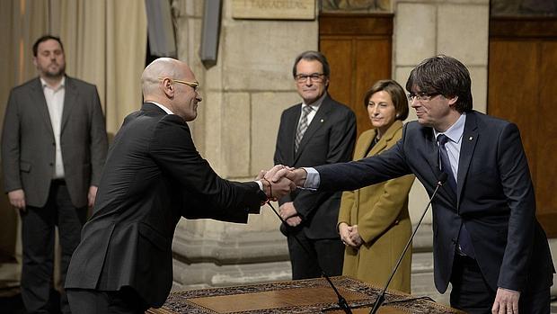 Romeva saluda a Puigdemont, en el momento de tomar posesión