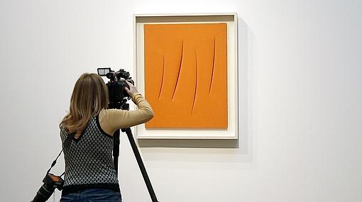 Un visitante graba la obra de Lucio Fontana, «Concetto spaziale, Attese», de 1964,