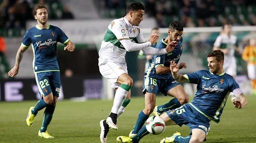 Cristian Herrera, en medio, durante un partido del Elche en Primera contra el Valadolid en diciembre de 2014