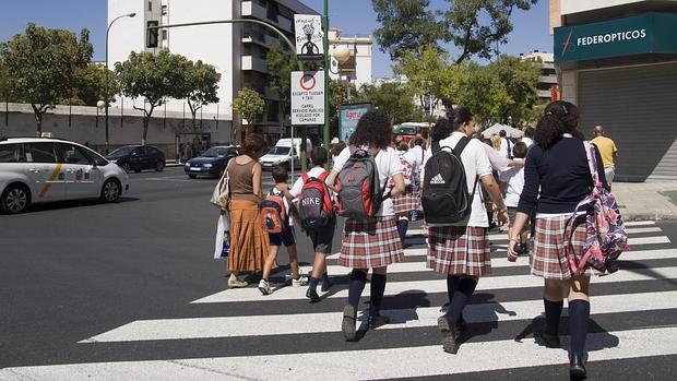 Un grupo de escolares cruza un paso de cebra a la salida del colegio