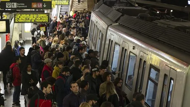 Usuarios del Metro de Barcelona esperan en el andén de la estación de Plaza España la llegada de un convoy