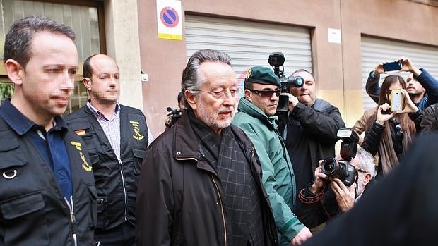 Alfonso Grau sale de su domicilio tras el registro, custodiado por la Guardia Civil