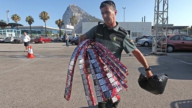 Un guardia con el tabaco hallado en el falso techo de un coche en Gibraltar