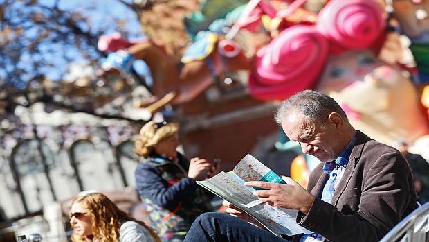 Imagen de un turistas observando un plano de Valencia en una imagen tomada este viernes